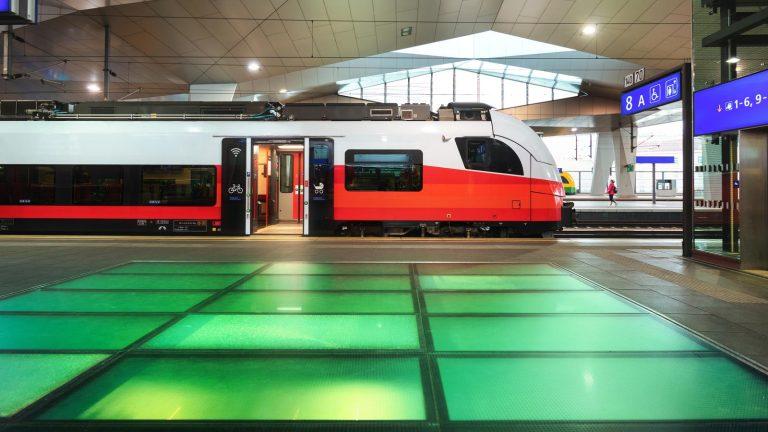 רכבת מהירה אדומה של חברת הרכבות האוסטרית ÖBB עוצרת ברציף תחנת הרכבת המרכזית של וינה